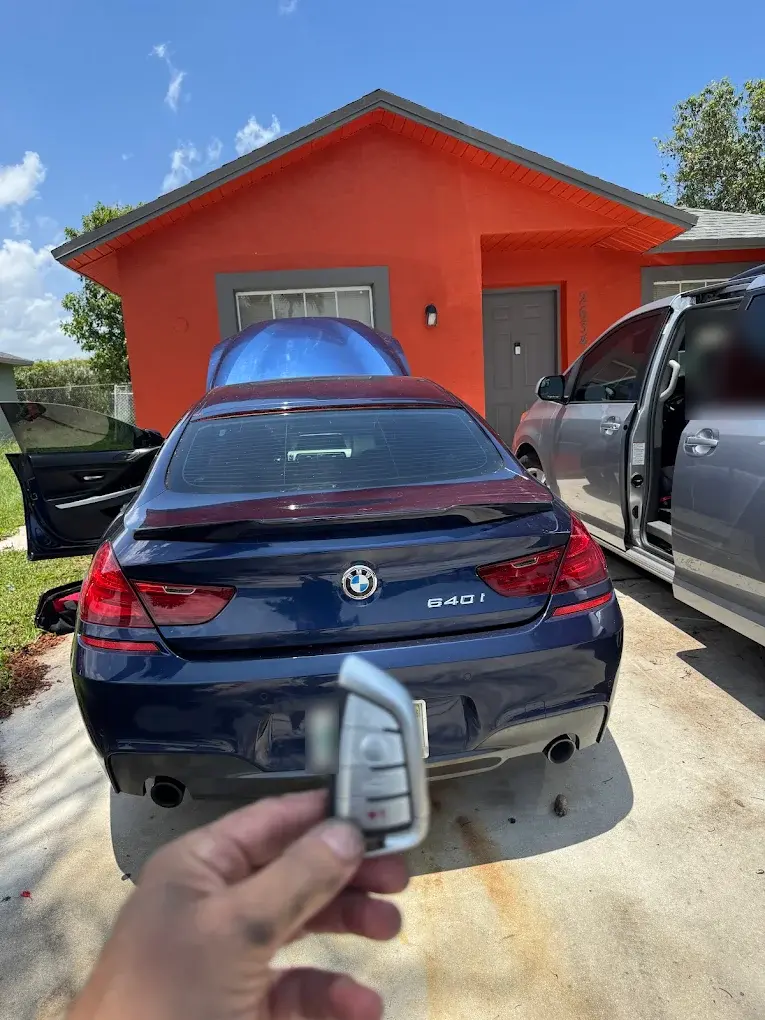 New BMW key fob next to the customer's car and the service van